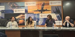 Un moment del Fòrum sobre Mobilitat Elèctrica en el tursime. A una taula, de cara al públic, hi ha quatre persones. A l'esquerra, el president d'Ecotxe, Alexandre Duran.