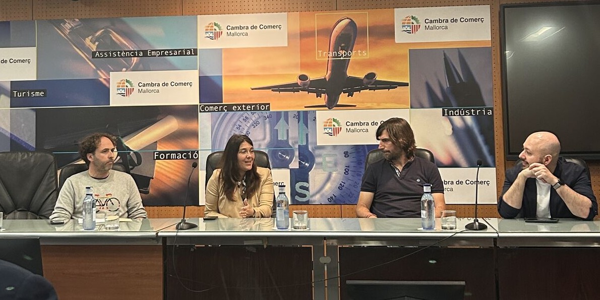 Un moment del Fòrum sobre Mobilitat Elèctrica en el tursime. A una taula, de cara al públic, hi ha quatre persones. A l'esquerra, el president d'Ecotxe, Alexandre Duran.